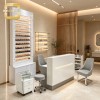 White Salon Reception Counter with Built-in Linear LED Light and Large Storage Cabinet for Cream Nail Salon